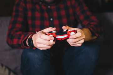 Close up of male hands holding a joystick and playing video games.