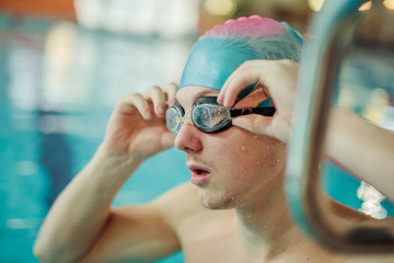 Portrait of a fit swimmer in the pool at leisure center wear mask