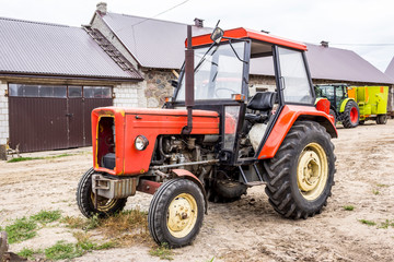 Old tractor for works in a fields ,where cultivated corn and grass for the cows .General view of the agricultural machine.Equipment for a dairy farm.