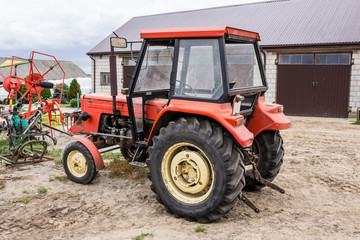 Old tractor for works in a fields ,where cultivated corn and grass for the cows .General view of the agricultural machine.Equipment for a dairy farm.