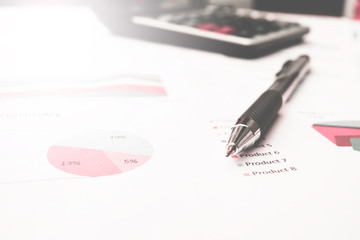 Pen on background of calculator and budget paper.