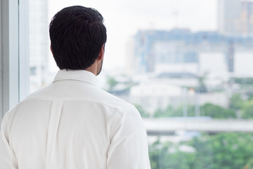 business man looking through office window