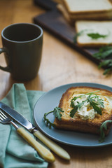 sandwich with egg and arugula on a plate is on the table