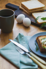 sandwich with egg and arugula on a plate is on the table