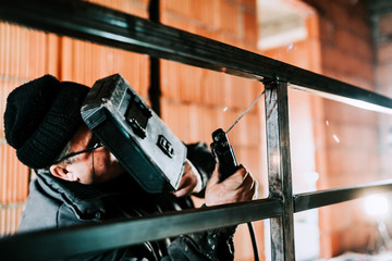 Middle aged caucasian man welding with professional tools