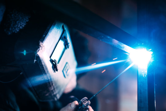 Close up details of professional construction worker welding metal structure