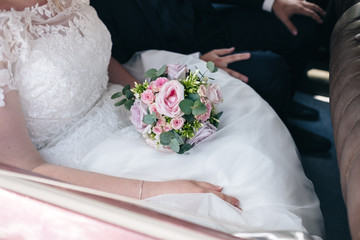 Bride carrying her bouquet in the car that brings them to the ceremony