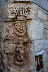 Fototapeta na wymiar Bassorilievo sul muro presso Castello di Vigoleno, in Emilia Romagna provincia di Piacenza, con le mura e la cittadina