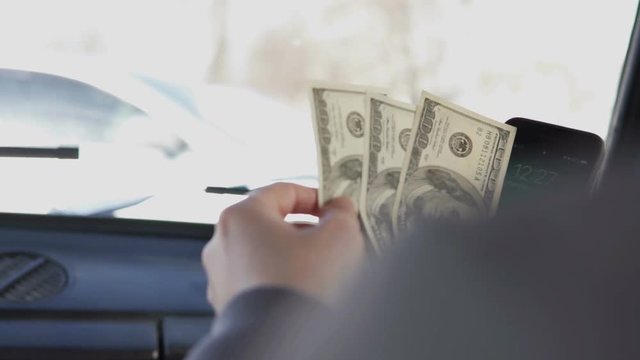 The guy counts dollars in the car