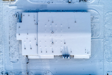 Large warehouse complex, the roof of the building is completely covered with snow. © nordroden