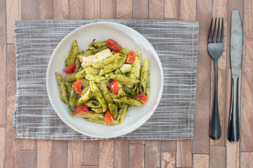 Pasta with pesto sauce and nuts on a the table