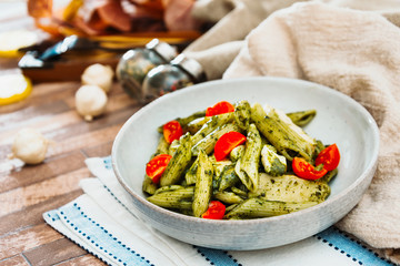 Pasta with pesto sauce and nuts on a the table