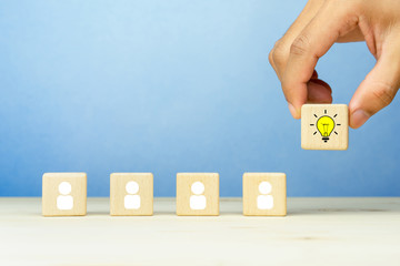 Brainstorming, Creative, New idea, innovation and solution concept. Hand picked a wooden cubes with the yellow light bulb and people icons symbol with copy space