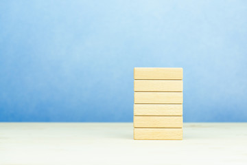 Piles of empty wooden blocks on a wooden table, a banner with space to copy the text.
