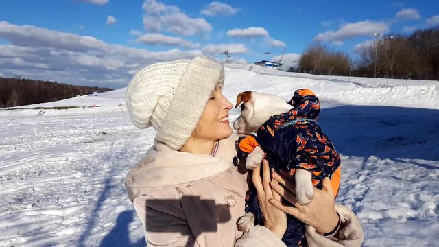 Adult woman hold her puppy outdoors