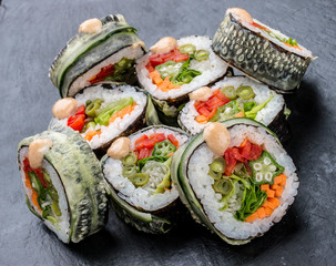 Sushi roll with vegetables on black background. Vegetarian dish.