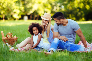 Fototapeta premium Picture of lovely couple with their daughter having picnic