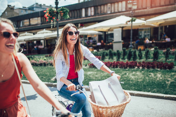 Two beautiful women shopping on bike in the city