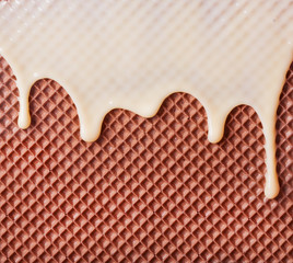 White hot chocolate on the wafer. Waffle covered with condensed milk close-up. White hot chocolate spreads on the wafer.