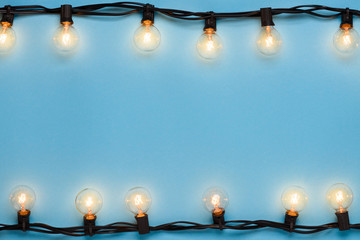 Garlands of lamps warm light edison lights on blue background with space for text