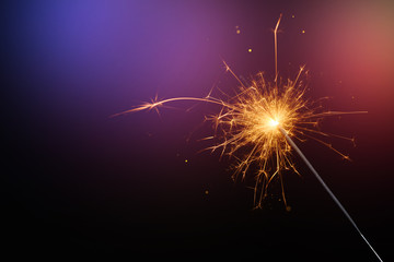Christmas sparkler or Bengal fire. New year sparkler glittering candle magic festive light on dark background.