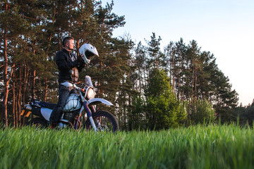 Motorcyclist on green grass off road, enduro, extreme sport, active lifestyle, adventure touring concept, enduro outdoor