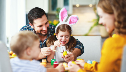  Happy easter! family mother, father and children paint eggs for holiday