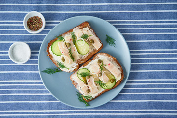 Herring smorrebrod - traditional Danish sandwiches. Black rye bread with herring on dark blue...