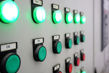 Closeup of Electric control panel with push buttons switch and light display in factory on background.