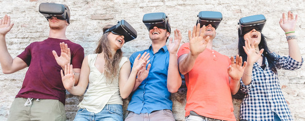 Young millennials friends wearing virtual reality glasses outdoor - Young people having fun with...