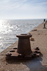 bollard on quayside with sun in background