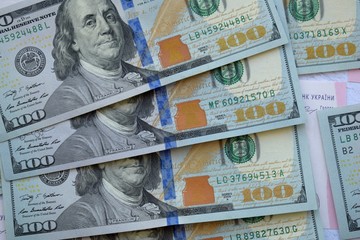 Fototapeta na wymiar American one hundred dollars banknotes and Ukrainian 200 hryvnia, money background