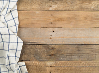 Blue and white checkered dishcloth on brown rustic wooden plank table flat lay top view from above