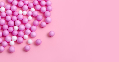 Pink and white small balls are scattered on the pink surface