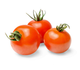 Three red cherry tomatoes with green spikes on a white isolated background. Close-up. Side view.