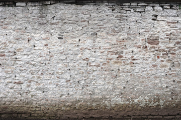 Decayed white painted stone wall