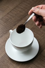 preparing hot coffee into a white mug