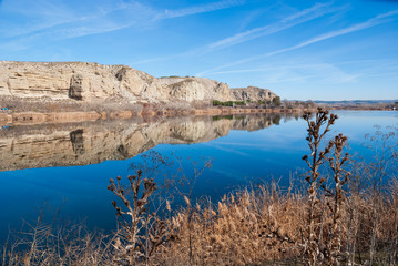 Reflection of mountains over blue lagoon in winter. Located in the town of Rivas in Madrid. Spain