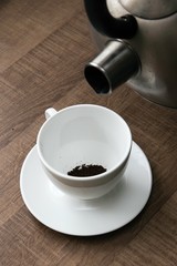 preparing hot coffee into a white mug