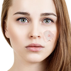 Obraz premium Woman with pimple on face peek from hole in foundation.