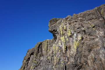 Mountain cliffs on the bank of the river against the blue sky