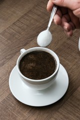 preparing hot coffee into a white mug