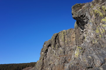 Mountain cliffs on the bank of the river against the blue sky