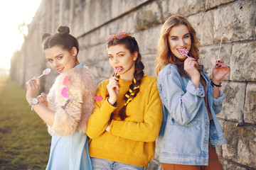 Grup of three girls with funny lips, glasses, stars, paper hearts on stick at the sunset having fun. Going crazy, smile at summer day. Hipster girls, colored dressed, with sunglasses and wrist watch.
