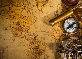 Fototapeta na wymiar Top view of vintage navigation equipment on old world map.