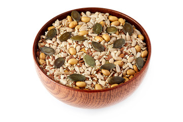 Mix of various healthy seeds including soy beans, sesame, pumpkin and sunflower seeds in wooden bowl isolated on white background