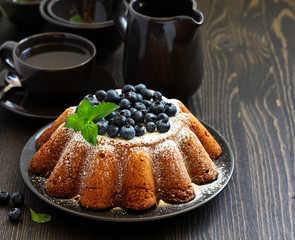 Vanilla cake (gugelhupf) with blueberries. dark background.