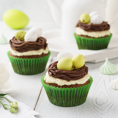 Easter chocolate cupcakes decorated with nest and candy eggs.