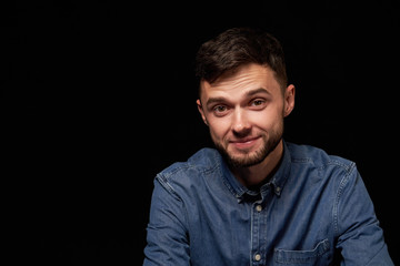 Handsome man in denim shirt looking at camera smiling