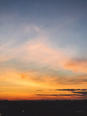 Naklejka premium Beautiful amazing sunset, view of city and sky. Blue and yellow sky with clouds, atmospheric scene of evening or morning. Dusk or dawn. Copy space